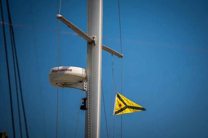 Slide: The Image of Radar and flag on 2005 Catalina 36 MkII sailboat mast against clear blue sky. - 8