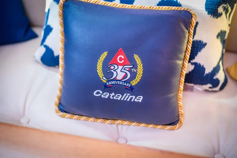 Slide: The Image of Blue Catalina 35th anniversary cushion on a patterned sofa, celebrating the 2005 Catalina 36 MkII. - 9