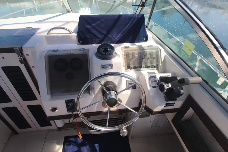 Slide: The Image of 1992 Grady-White Gulfstream 232 boat cockpit with steering wheel and control panel. - 10