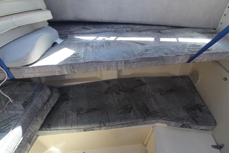 Slide: The Image of 1992 Grady-White Gulfstream 232 cabin interior with cushioned seating and storage. - 18