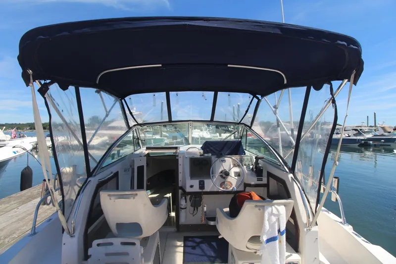 Slide: The Image of 1992 Grady-White Gulfstream 232 boat interior with steering wheel and seating, docked at marina. - 21