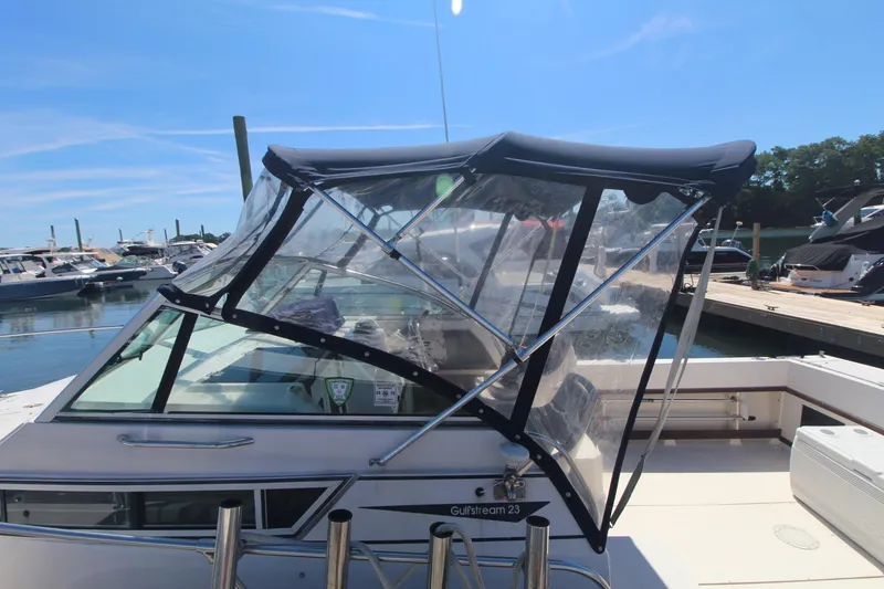 Slide: The Image of 1992 Grady-White Gulfstream 232 boat with canopy, docked at marina under clear blue sky. - 6