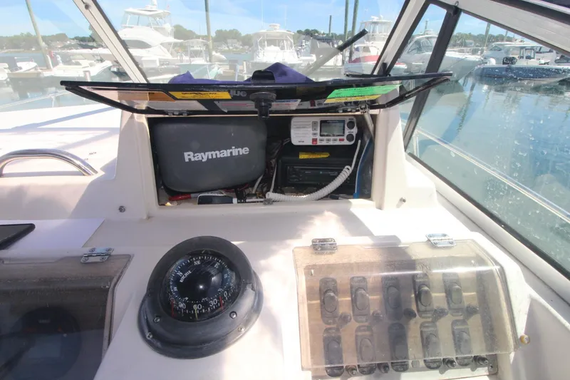 Slide: The Image of 1992 Grady-White Gulfstream 232 boat dashboard with Raymarine equipment and compass. - 9
