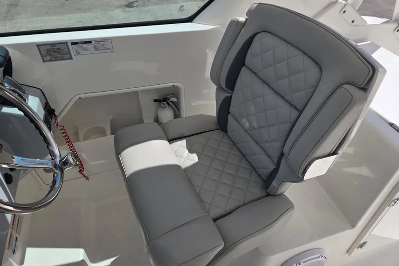 Slide: The Image of 2023 Pursuit DC 266 Dual Console boat seat with quilted design and steering wheel. - 10