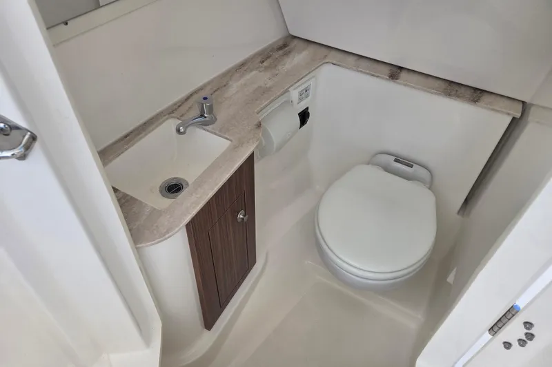 Slide: The Image of 2023 Pursuit DC 266 Dual Console boat bathroom with sink and toilet. - 14