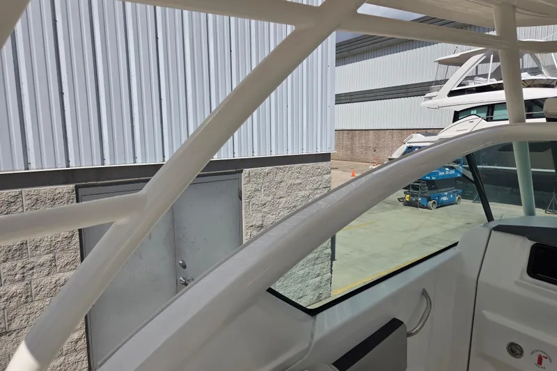 Slide: The Image of 2023 Pursuit DC 266 Dual Console boat detail near industrial building. - 17