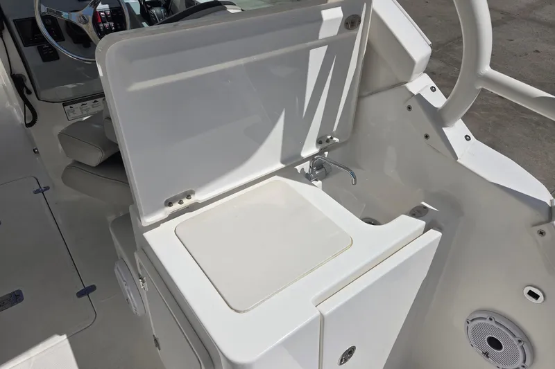 Slide: The Image of 2023 Pursuit DC 266 Dual Console boat interior with sink and steering wheel. - 18