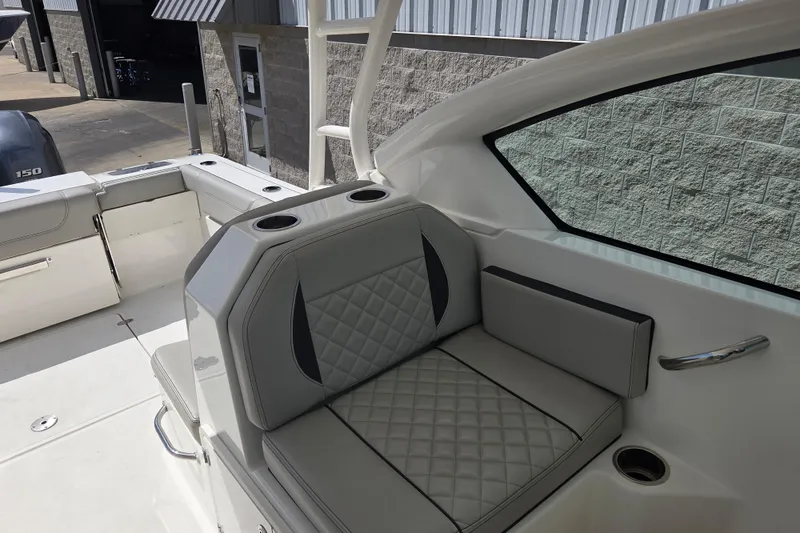 Slide: The Image of 2023 Pursuit DC 266 Dual Console boat interior with cushioned seating and cup holders. - 27