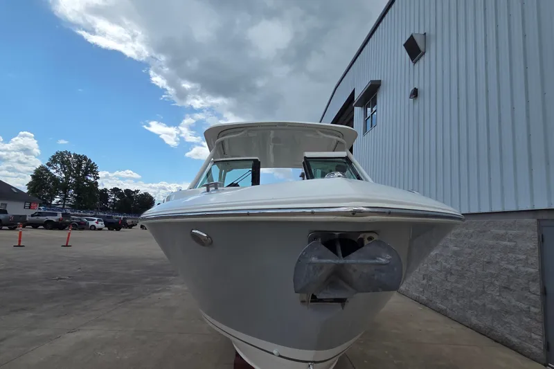 Slide: The Image of 2023 Pursuit DC 266 Dual Console boat docked near a building under a cloudy sky. - 29