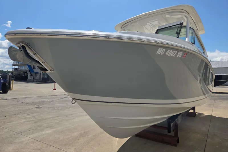 Slide: The Image of 2023 Pursuit DC 266 Dual Console boat on a sunny dockside. - 3