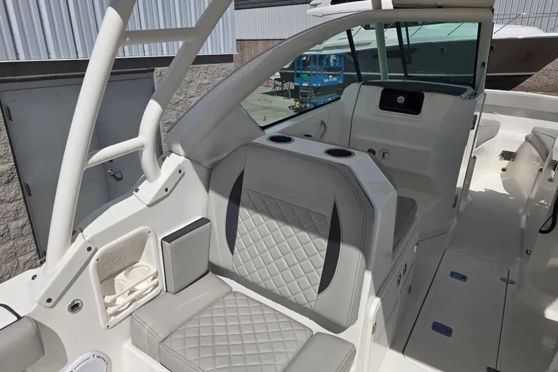 Slide: The Image of 2023 Pursuit DC 266 Dual Console boat interior with cushioned seating and modern design. - 7