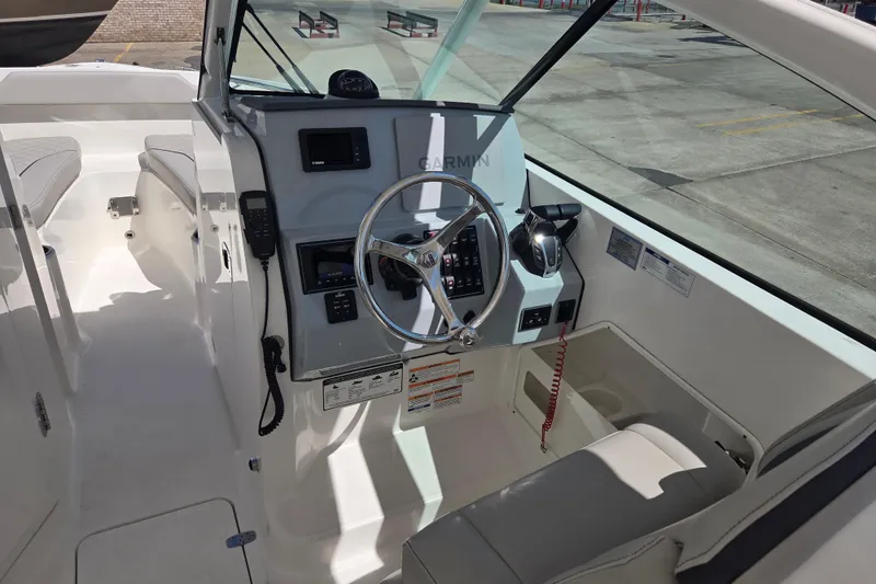 Slide: The Image of 2023 Pursuit DC 266 Dual Console boat interior with steering wheel and controls. - 8