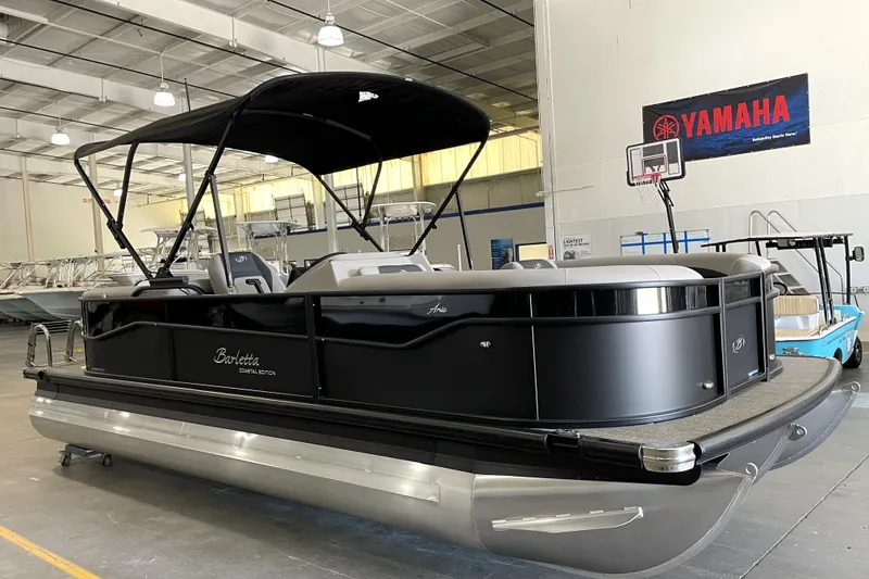 Slide: The Image of 2026 Barletta ARIA 22QC pontoon boat in showroom, featuring sleek black design and canopy. - 5