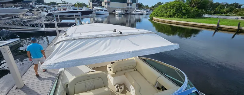 Slide: The Image of 2018 Regal 33 XO boat docked at marina, featuring spacious seating and canopy. - 18