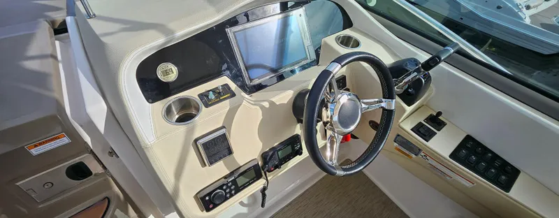 Slide: The Image of 2018 Regal 33 XO boat dashboard with steering wheel and control panel. - 21
