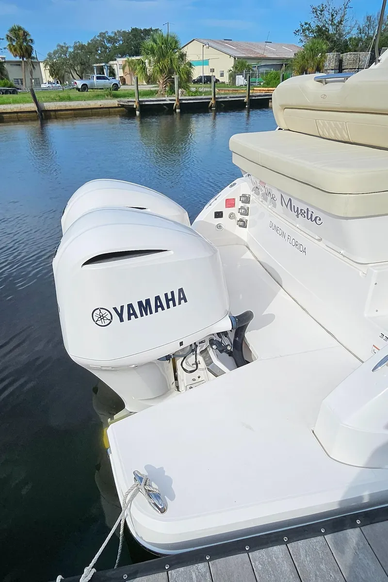 Slide: The Image of 2018 Regal 33 XO boat with Yamaha outboard engine docked by the water. - 30