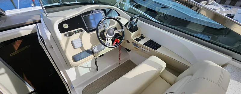 Slide: The Image of 2018 Regal 33 XO boat cockpit with steering wheel and navigation controls. - 6
