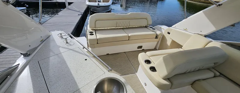 Slide: The Image of 2018 Regal 33 XO boat interior with beige seating, docked by the water. - 9