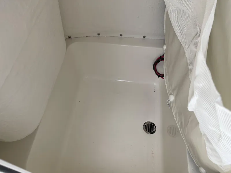 Slide: The Image of 2025 Key West 230 Bay Reef boat storage compartment with drain. - 15