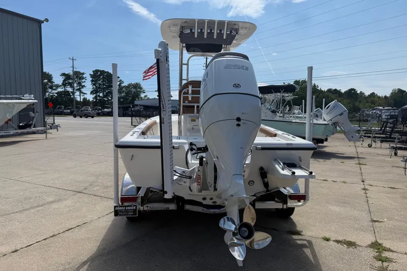 Slide: The Image of 2026 Key West 230 Bay Reef boat with powerful outboard motor, parked outdoors. - 2