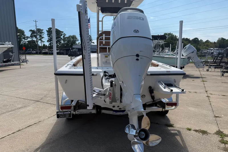 Slide: The Image of 2026 Key West 230 Bay Reef boat with powerful outboard motor, parked outdoors. - 5
