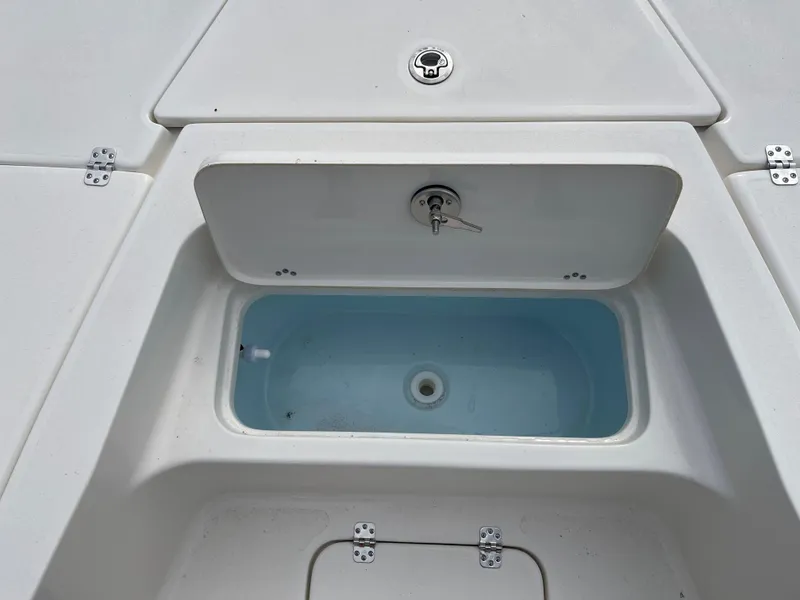 Slide: The Image of Key West 230 Bay Reef 2025 livewell with open lid, showcasing interior. - 9