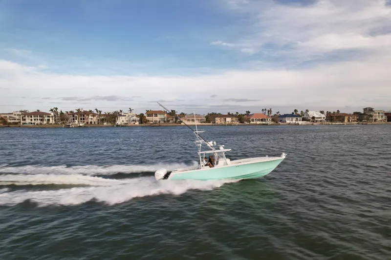 Slide: The Image of 2013 SeaVee 390B boat cruising on water near coastal homes under a blue sky. - 10