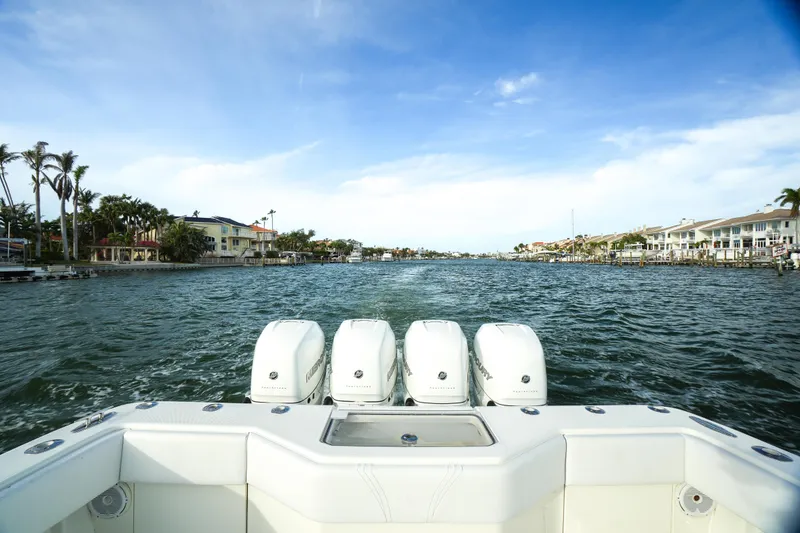 Slide: The Image of 2013 SeaVee 390B boat with four engines cruising on a scenic waterway. - 14