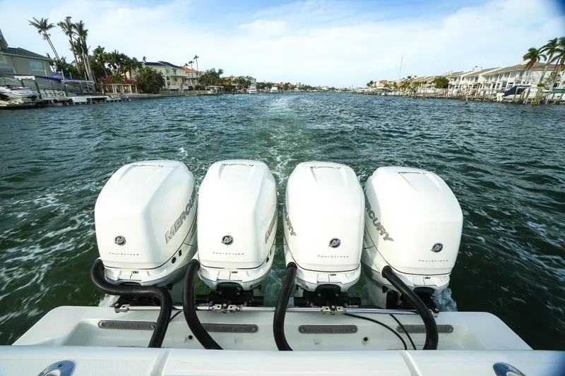 Slide: The Image of 2013 SeaVee 390B boat with four powerful outboard engines cruising on a scenic waterway. - 15
