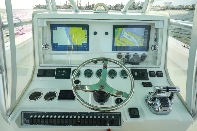 Slide: The Image of 2013 SeaVee 390B boat dashboard with dual navigation screens and steering wheel. - 23