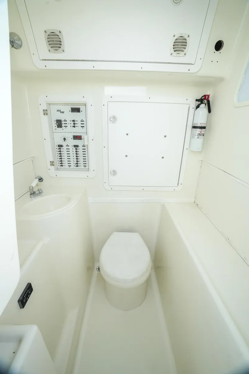 Slide: The Image of 2013 SeaVee 390B boat bathroom with toilet, control panel, and fire extinguisher. - 32