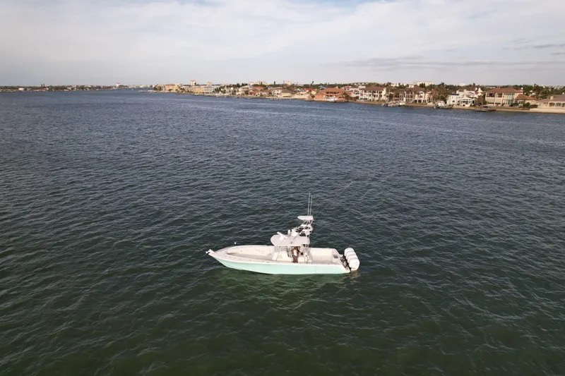 Slide: The Image of 2013 SeaVee 390B boat on calm waters near coastal town. - 8
