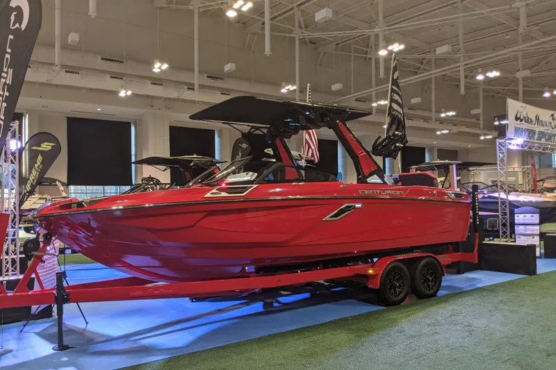 Slide: The Image of 2023 Centurion Ri245 boat displayed indoors on a trailer at a boat show. - 1