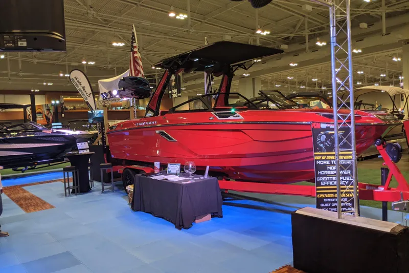 Slide: The Image of 2023 Centurion Ri245 boat displayed at an indoor exhibition, featuring a vibrant red exterior. - 2