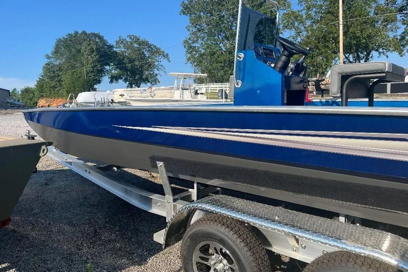 Slide: The Image of 2026 Alweld 2270 Vortex boat on trailer, blue and black design, parked outdoors. - 3
