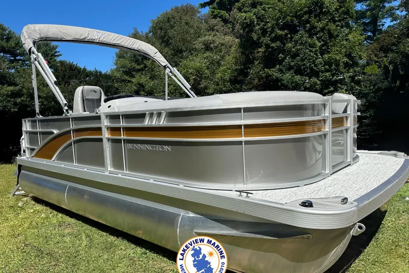 The Image of 2025 Bennington 18 SXL pontoon boat on grass with trees in background. - 0