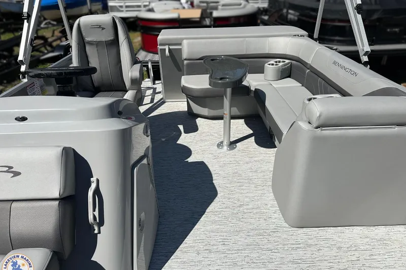 Slide: The Image of 2025 Bennington 18 SXL pontoon boat interior with gray seating and steering console. - 2