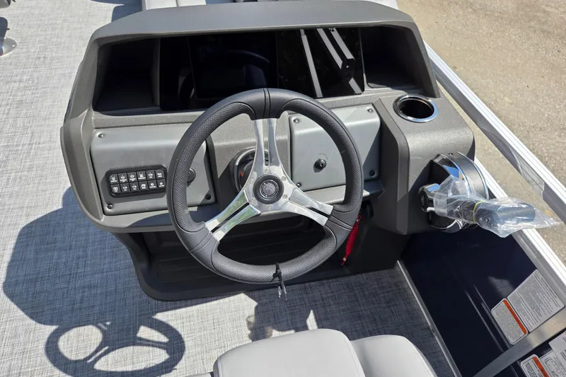 Slide: The Image of 2026 Sun Tracker SportFish 20 DLX boat dashboard with steering wheel and controls. - 12
