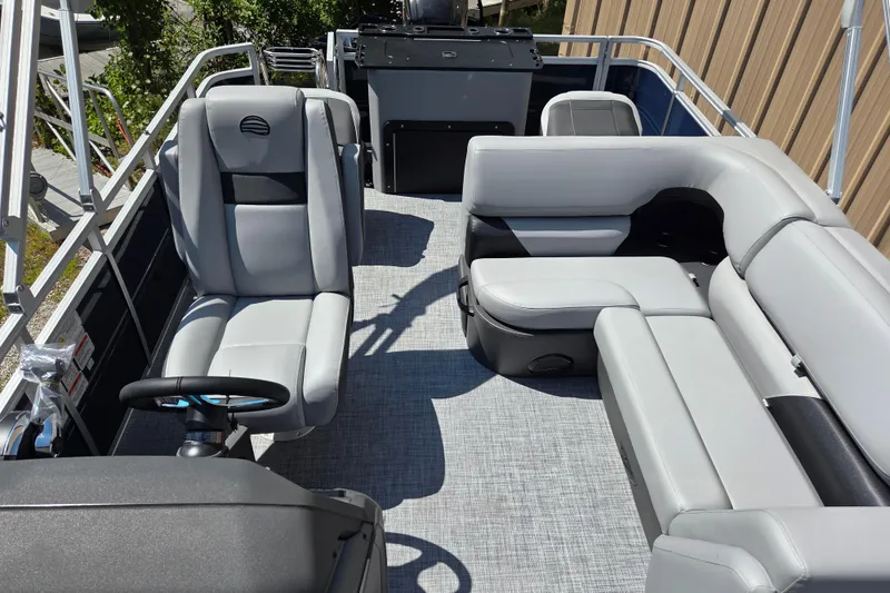 Slide: The Image of 2026 Sun Tracker SportFish 20 DLX pontoon boat interior with gray seating and steering console. - 9