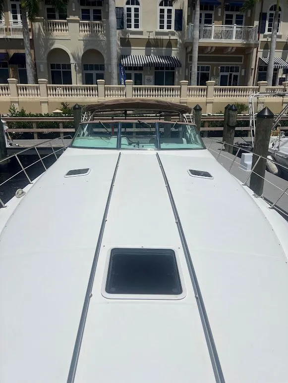 Slide: The Image of 1996 Sea Ray 400 Sundancer yacht docked near waterfront buildings. - 2