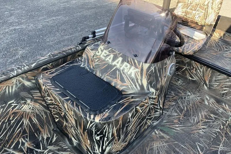 Slide: The Image of 2020 SeaArk RX 170 boat with camouflage design and windshield, parked on pavement. - 14