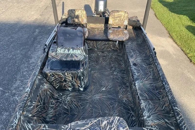 Slide: The Image of 2020 SeaArk RX 170 boat with camouflage interior design, parked on pavement. - 18