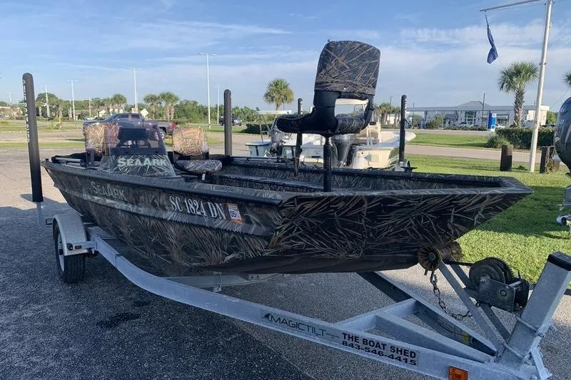 Slide: The Image of 2020 SeaArk RX 170 boat on trailer, camo design, parked outdoors. - 5