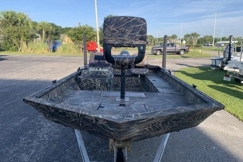 Slide: The Image of 2020 SeaArk RX 170 boat with camouflage design, parked outdoors on a sunny day. - 6