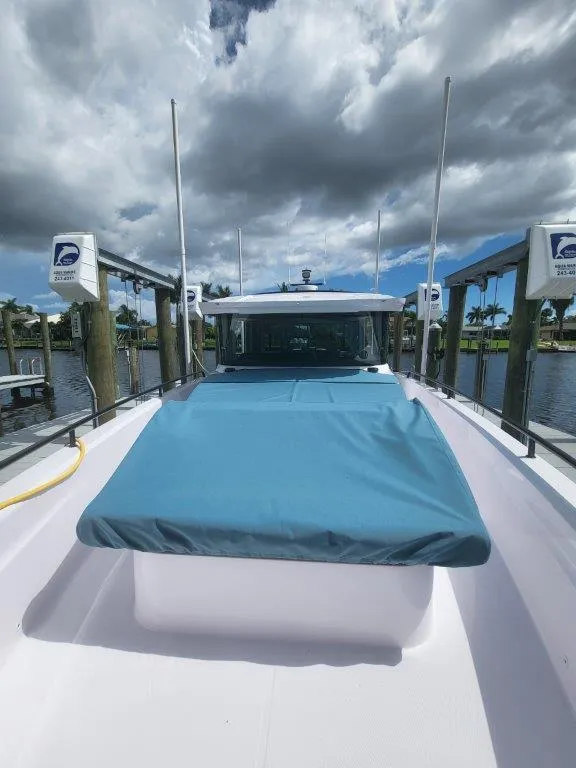 Slide: The Image of 2024 Axopar 37 XC CROSS CABIN docked under cloudy skies. - 22