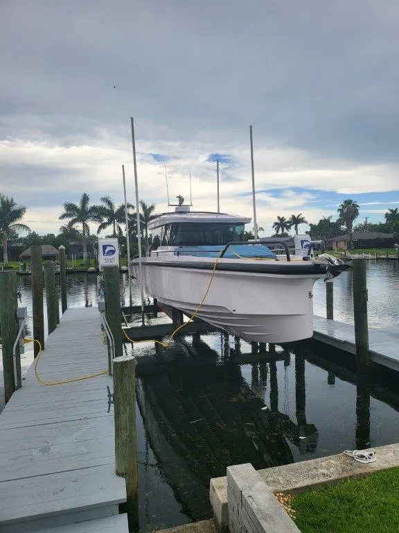 Slide: The Image of 2024 Axopar 37 XC CROSS CABIN boat docked at marina with palm trees. - 4
