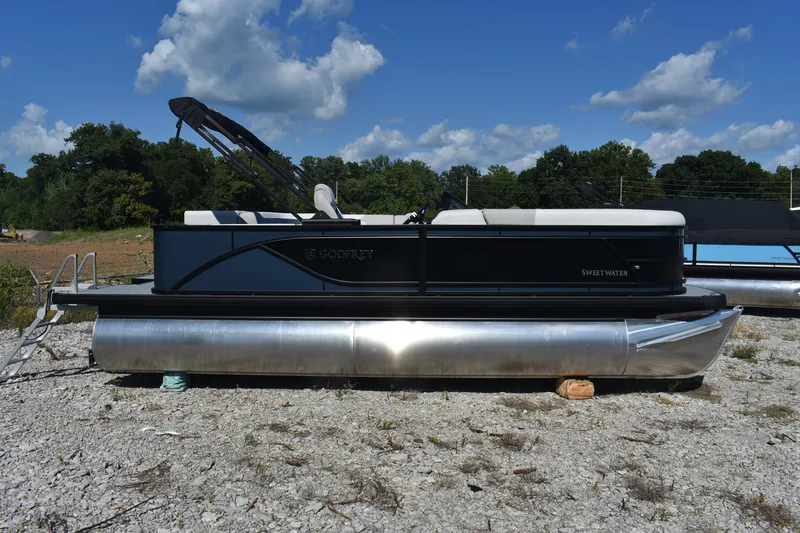 Slide: The Image of 2026 Godfrey Sweetwater 2086 C pontoon boat on gravel, under a clear blue sky. - 6