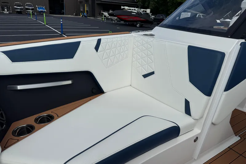 Slide: The Image of 2026 Nautique Super Air Nautique GS22 interior with white and blue seating, cup holders. - 11