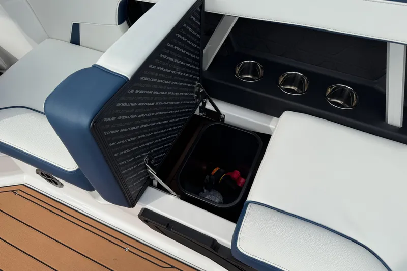 Slide: The Image of 2026 Nautique Super Air Nautique GS22 interior with storage compartment and cup holders. - 22