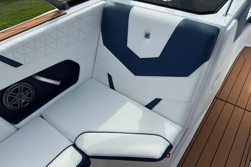 Slide: The Image of 2026 Nautique Super Air Nautique GS22 interior with white and navy seating, teak flooring. - 23
